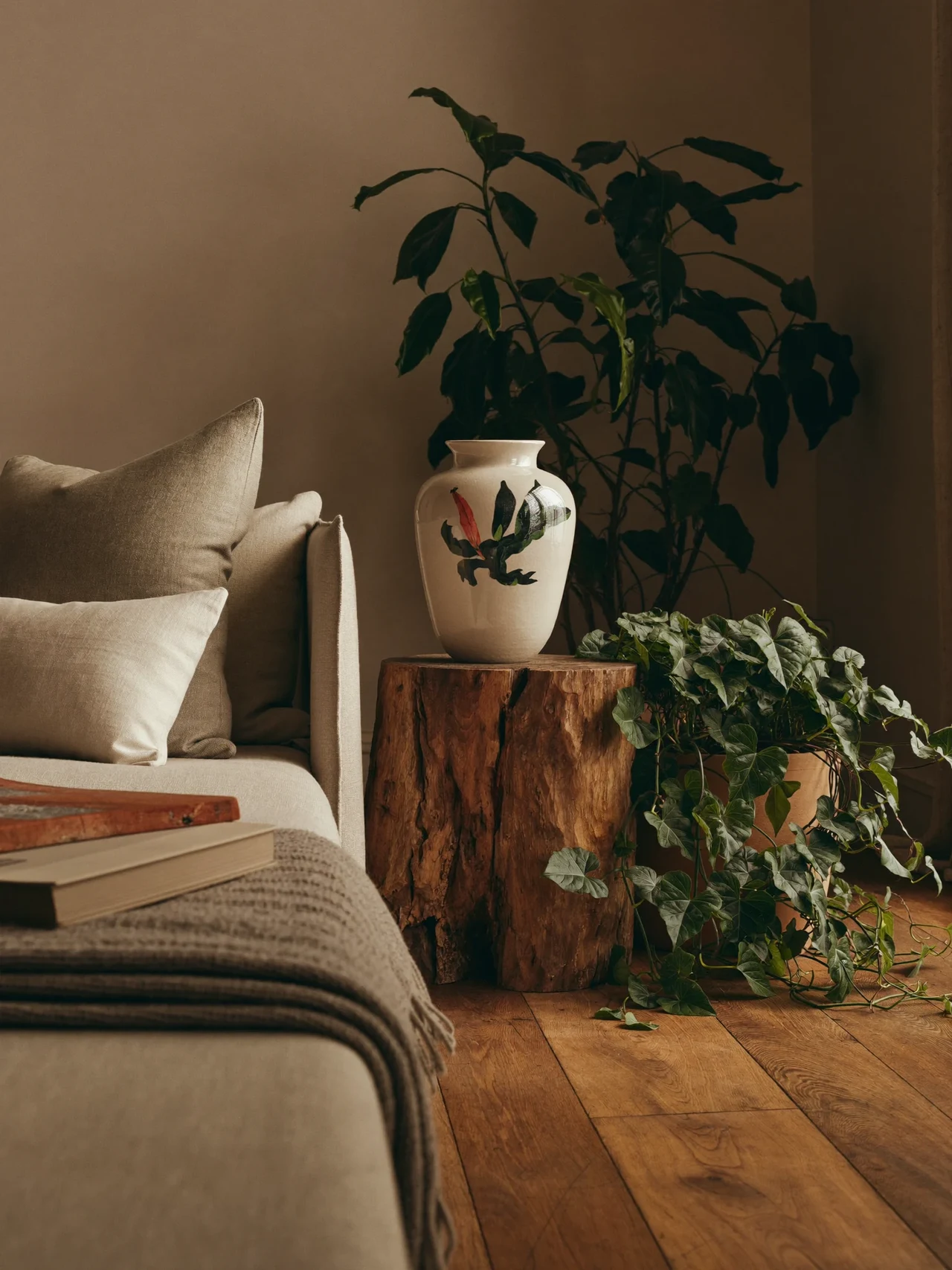 Angolo di soggiorno milanese al sole con ceramiche, tessili e piante